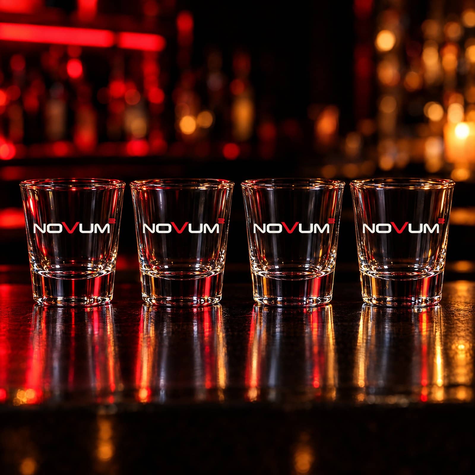 Vier Schnapsgläser mit NOVUM-Logo auf einer Bar